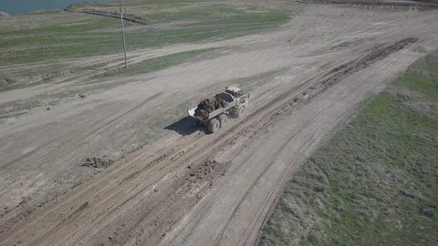 Vislock river, Poland - may 2, 2018:The excavator loads the dump truck with soil. Land works in the quarry of river gravel. Work on a special technique produced by ?AT.Panorama from fly droning