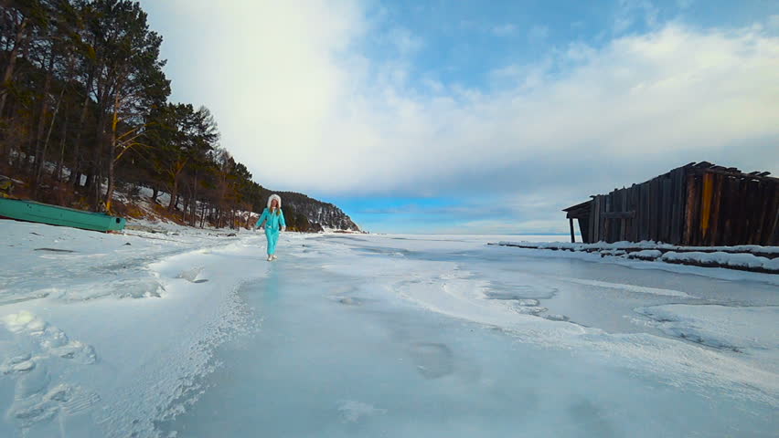 The young woman is skating on the ice
Frozen Baikal lake Blue sky
Ski equipment