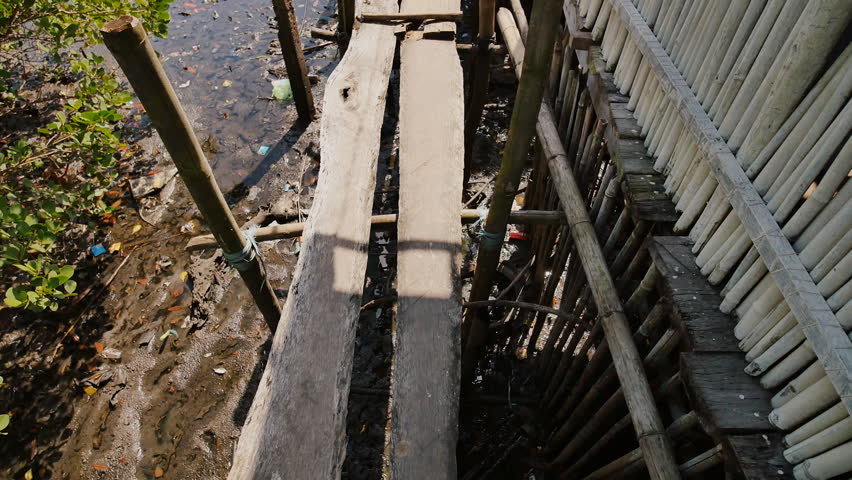 Wooden bridges from planks on high water. Houses in the Filipino slums for poor people. Poverty of people and families.