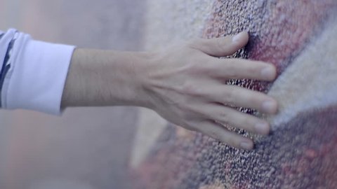 Man Walks Along Colorful Mural Wall And Touches The Side Of It (Slow Motion, Closeup Of His Hand)