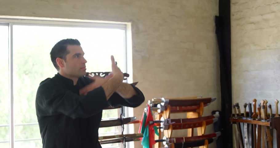 Kung fu fighter practicing martial arts in fitness studio 4k