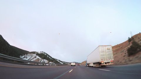 POV-Driving on Interstate highway I70 in the mountains at sunrise.