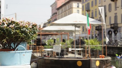 Milan, Naviglio Pavese Italian Flag on a Boat with Spring Flowers in Foresight