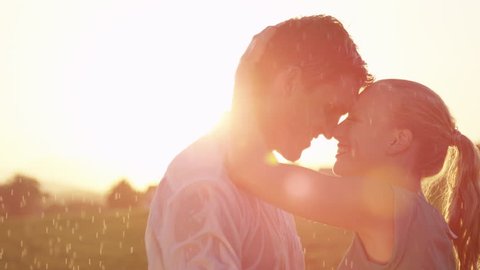 SLOW MOTION, CLOSE UP, LENS FLARE: Young Caucasian woman and man madly in love hold each other tight while dancing at sunset. Lovely couple shares unforgettable moments as the dance in golden nature. स्टॉक वीडियो
