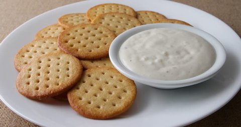 Video of dipping a snack cracker into a bowl of ranch dressing with crackers to the side.
