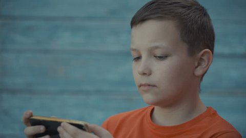 Young teenager playing game on smartphone. 4k footage