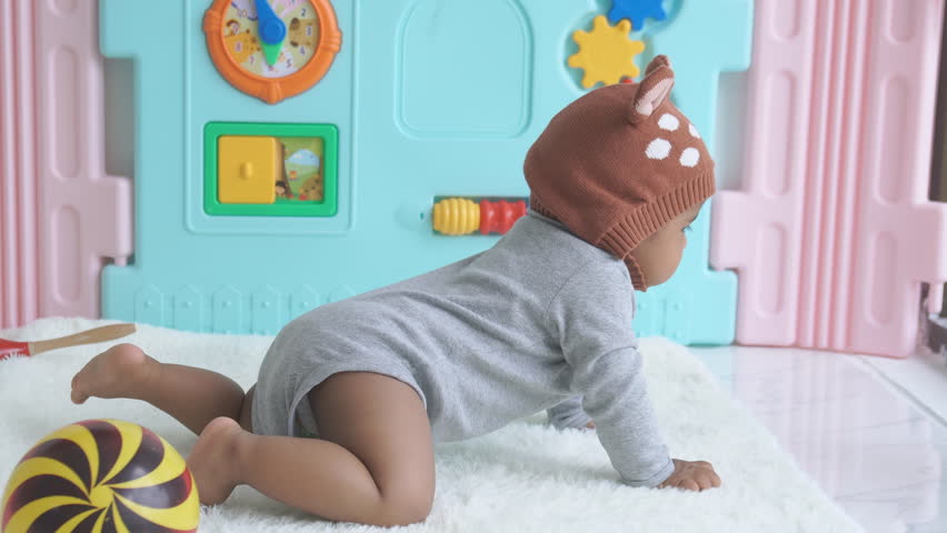 Cute little baby lying play plastic ball on soft blanket