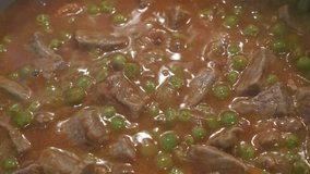 Cooking of meat and green peas 4K footage