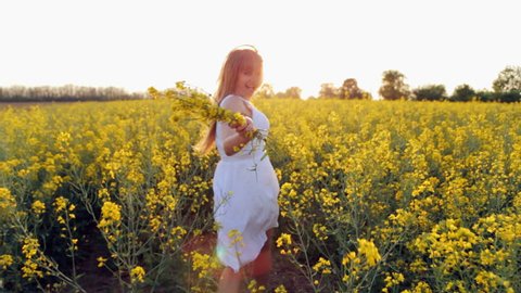 The girl runs on the flower field