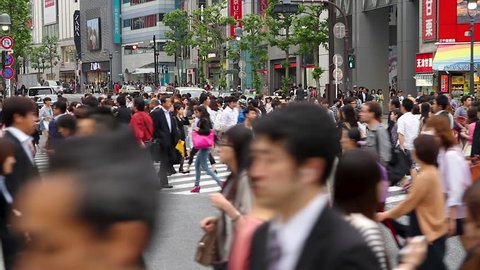 SHIBUYA-KU, TOKYO – MAY 14, 2014: People walking the Shibuya crossing, probably the busiest pedestrian crossing in the world, Tokyo, Japan 