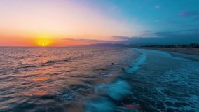 Sunset time-lapse of Venice Beach, California with surfers and swimmers