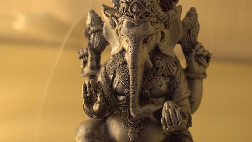 ganesha as the god of Hinduism. Ganesha figurine on a white background with incense close-up  Royalty-Free Stock Footage #1010847434