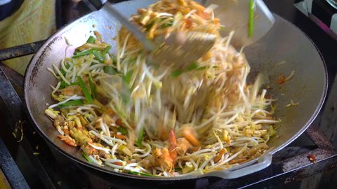 Thailand's national dishes (Pad Thai),Chef cooking stir-fried noodles with egg, vegetable,tofu and shrimp on a hot frying pan.Pad thai is the most delicious and popular foods in the world.