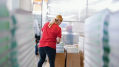 Female worker puts printed magazines in a box