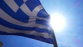 Slow motion video of Greek flag waving in deep blue sky
