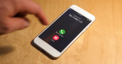 A cellular telephone on a desk rings with a phone call from a caller with no caller ID. The call is ignored. Phone number and screen are fictional.	 	