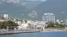 Yalta, Crimea - May 1, 2018: Embankment of the sea city, on which people walk. A sea city in the mountains