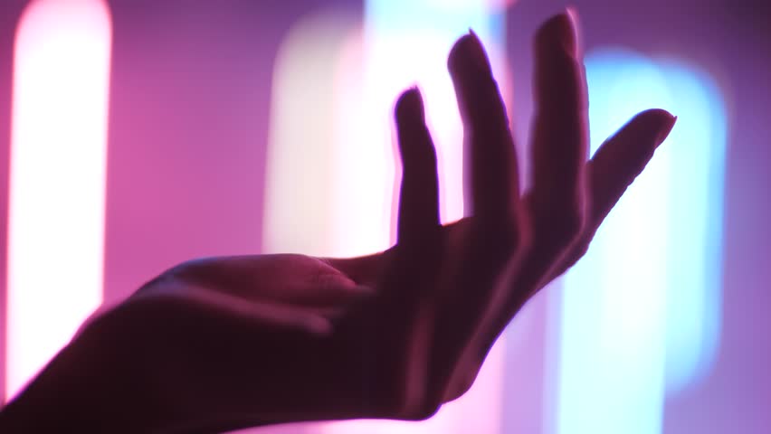 closeup side view young woman beautiful hand palm turns slowly in pink blue lights background Royalty-Free Stock Footage #1010857910