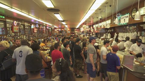 Busy restaurant. Men serving food in the counter. Katz's delicatessen - August 2017: Manhattan, New York City, NY, US