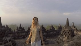 SLOW MOTION video of travel girl embracing sunrise at Borobudur temple, Indonesia . People discovery Asia concept 