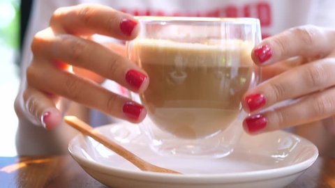 Female Drinking Coffee. Closeup Of Hands With Transparent Double Wall Glass Coffee Cup.