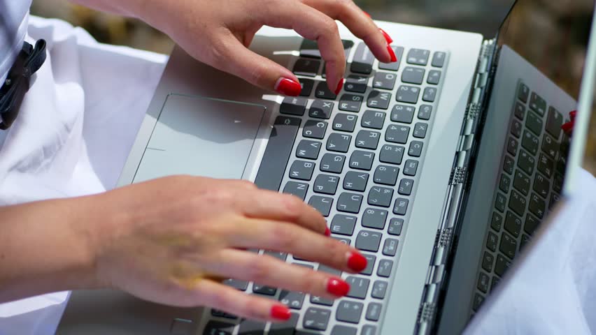 summer, outdoors. close-up of female hands with bright red manicure, type on the laptop keyboard.  Royalty-Free Stock Footage #1010869913
