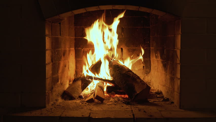 Burning Fire In The Fireplace. Wood And Embers In The Fireplace Detailed fire background. A looping clip of a fireplace with medium size flames | Shutterstock HD Video #1010871713