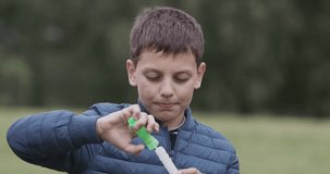 Young boy boy blows a bubbles in the garden. raw s-log2 Video footage in Ultra HD video 4k (4096x2160)
