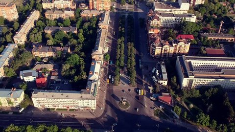 Main Poltava city square with cars and trees in sunrise light.