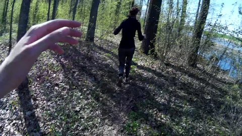 Chasing girl through the woods. Stalker or killer runs after terrified woman in a forest. POV view
