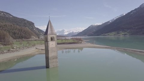 Aerial view of Bell tower in the Resia Lake, Italy, 4k, dlog