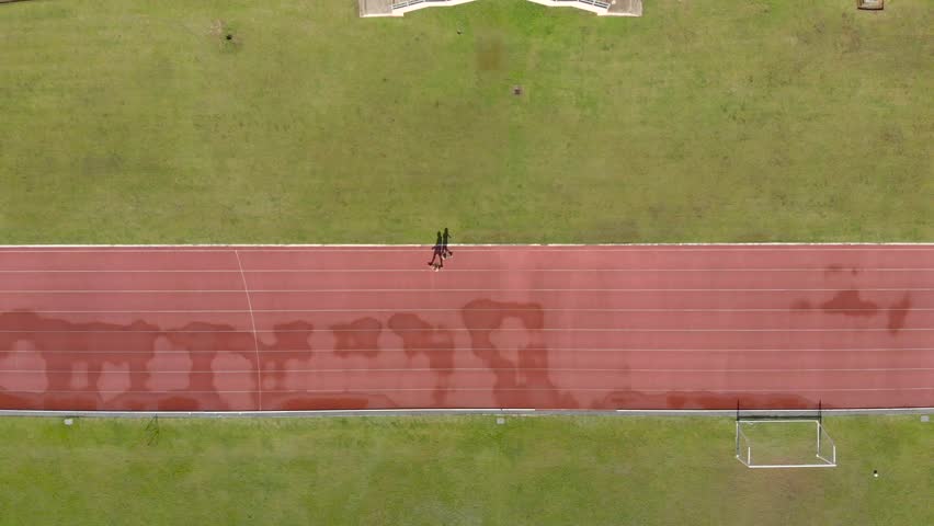 People running for exercise at stadium after raining in Asian country