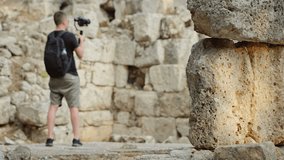 A traveler shoots video footage in the Ruins of the Antique City
