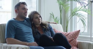 Young couple impersonating characters on television while sitting on couch
