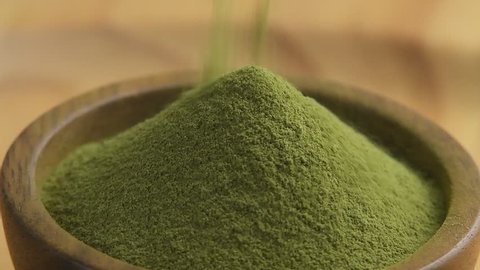 Green tea powder in wood bowl