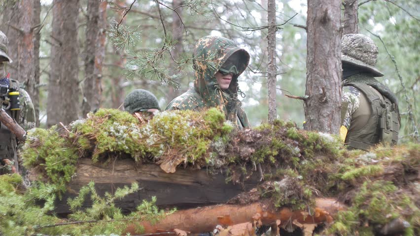 Soldiers in camouflage with combat weapons are being fired in the shelter of the forest, the military concept 4k