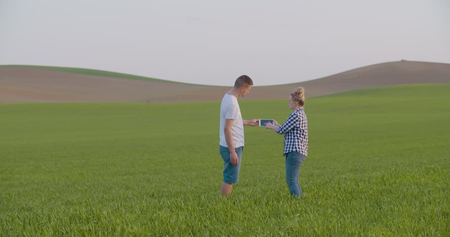Farmers Discussing Over Digital Tablet In Middle Of Farm