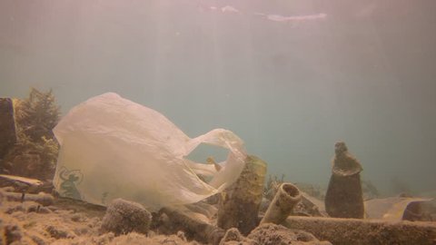 Plastic pollution of ocean. Water bottles and carrier bags dumped in sea  Stockvideó