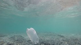 Underwater footage of plastic bag drifting in sea. Pollution of ocean environmental problem