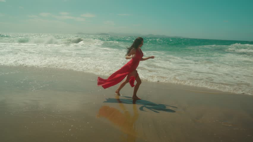 Sensual Brunette red dress run in the beach