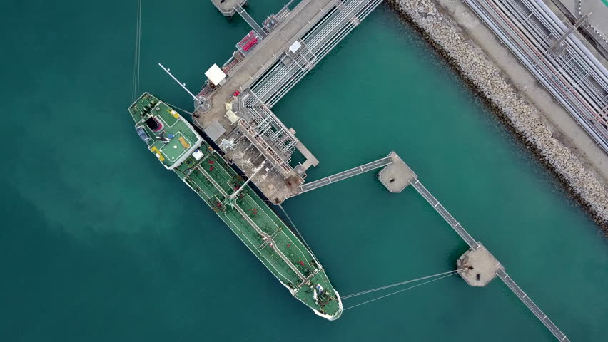 Aerial view crude oil and gas tank farm or oil and gas terminal building construction factory, Business power energy fuel chemical petroleum product, tanker cargo ship boat offshore at oil terminal. Royalty-Free Stock Footage #1010910887