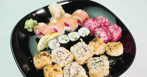 large plate of sushi sets of rolls spinning around its axis