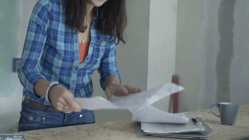 Young woman reading blueprints and checking her new home
 | Shutterstock HD Video #1010916119