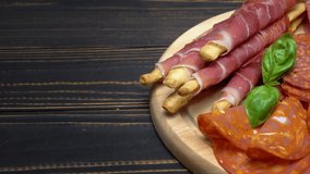 Video of italian meat plate - sliced prosciutto, sausage and grissini