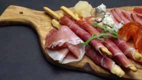 Video of italian meat plate - sliced prosciutto, sausage, grissini and parmesan