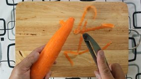 Chef peeling carrot top view
