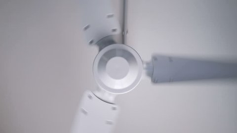 white metal fan spinning on the ceiling