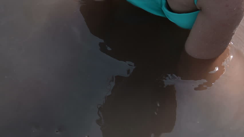 Young woman applying mud from the bottom of bitter-salty lake. Therapy and treatment with nature