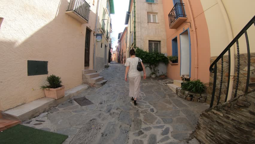 young woman in a dress walking on the streets of the city of Collioure in the eastern Pyrenees, Roussillon in southern of France