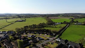 Aerial drone footage of suburban houses and fields in Scotland, UK 